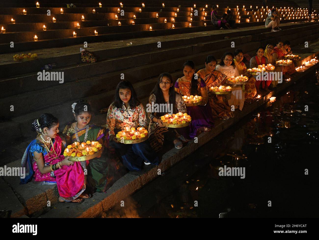 Mumbai, Indien. November 2021. Frauen und Kinder sahen während der Feier Diyas (irdenen Lampen) auf Tellern im Banganga-Wasserbehälter halten. Dev Diwali wird von Hindus durch das Anzünden von Diyas (irdenen Lampen) gefeiert. Es gedenkt auch Lord Shivas Sieg über die Asuras (Dämonen). Kredit: SOPA Images Limited/Alamy Live Nachrichten Stockfoto