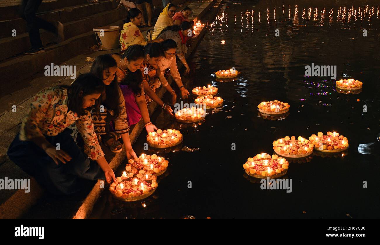 Mumbai, Indien. November 2021. Während der Feier tauchen Frauen Diyas (Erdlampen) im Banganga-Wasserbehälter ein. Dev Diwali wird von Hindus durch das Anzünden von Diyas (irdenen Lampen) gefeiert. Es gedenkt auch Lord Shivas Sieg über die Asuras (Dämonen). Kredit: SOPA Images Limited/Alamy Live Nachrichten Stockfoto