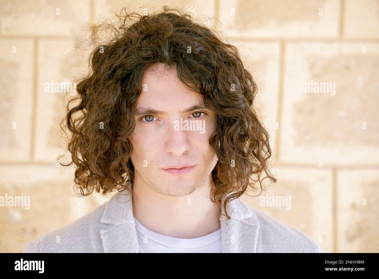 Porträt eines ernsthaften jungen Mannes 30 Jahre alt lockiges Haar mediterrane Merkmale Stockfoto