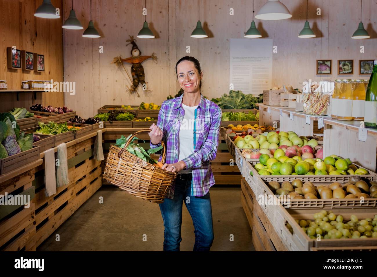 Portrait von schönen Brünette Mädchen Wahl Obst und Gemüse auf dem Bauernmarkt. Nachhaltiger Lebensstil Stockfoto