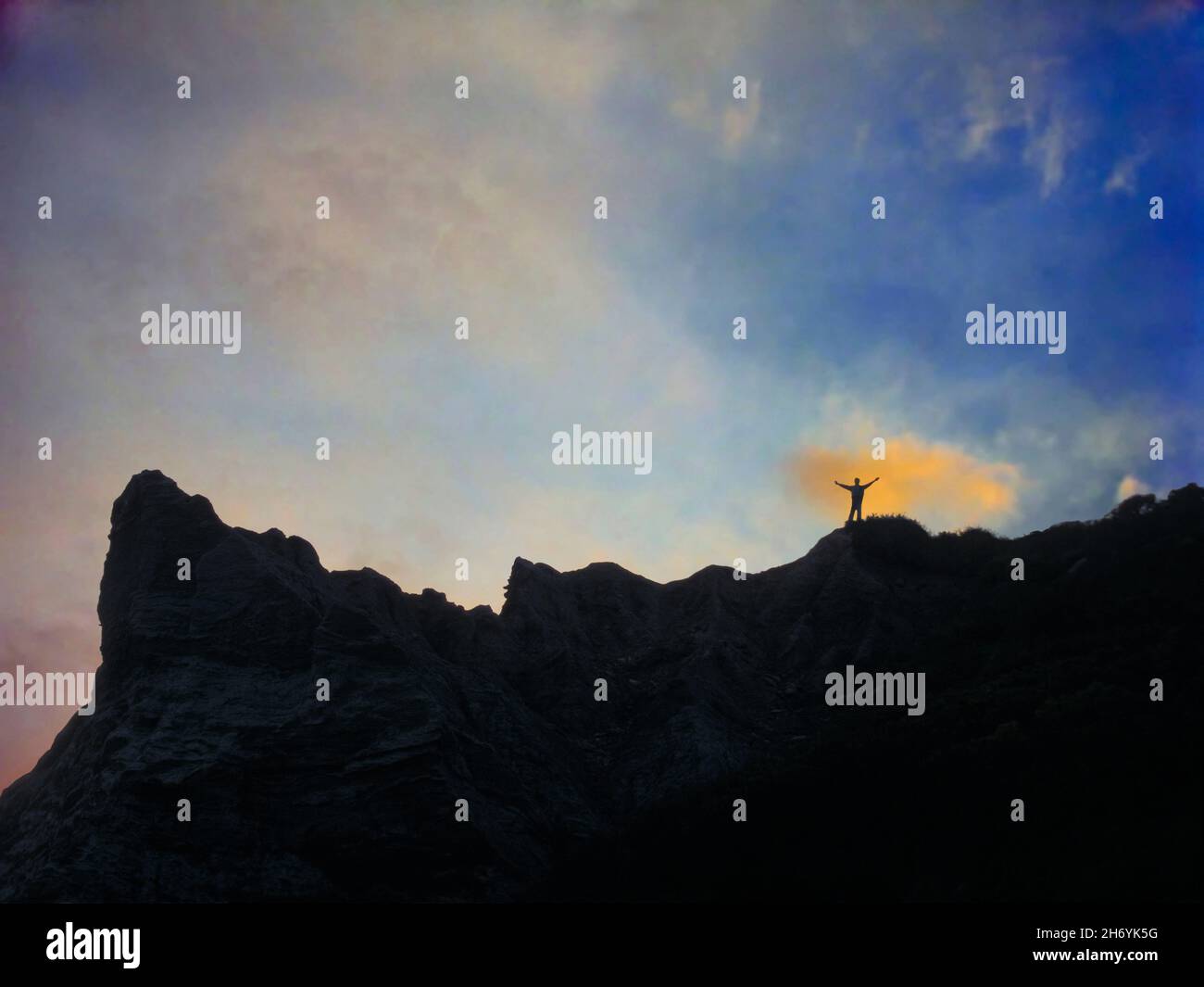 Ein Wanderer feiert den Sonnenaufgang auf einem Bergrücken Stockfoto