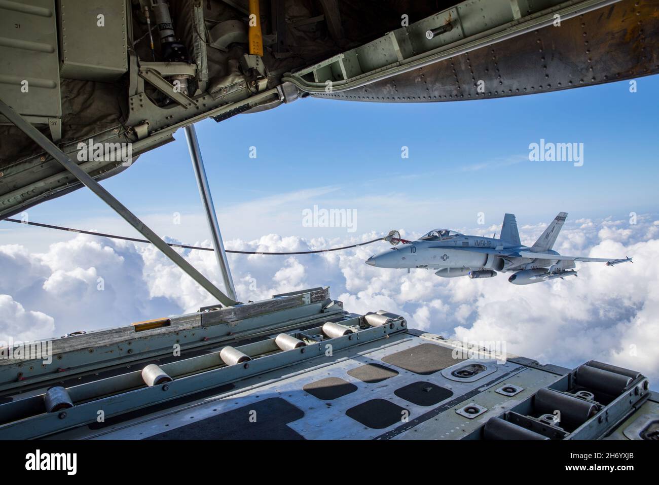 Ein U.S. Marine Corps F/A-18 Hornet Flugzeug mit Marine Fighter Attack Squadron 112 erhält Treibstoff von einem KC-130J Super Hercules Flugzeug mit Marine Aerial Refueller Transport Squadron 152 während einer Luftbetankungsübung in Japan, 16. November 2021. Marineinfanteristen mit VMFA-112, die aus der Naval Air Station Joint Reserve Base Fort Worth, Texas, stammen, sind im Marine Corps Air Station Iwakuni im Einsatz, um die regionale Stabilität und einen freien und offenen Indo-Pazifik-Raum zu erhalten. (USA Marine Corps Foto von Sgt. Booker T. Thomas III) Stockfoto