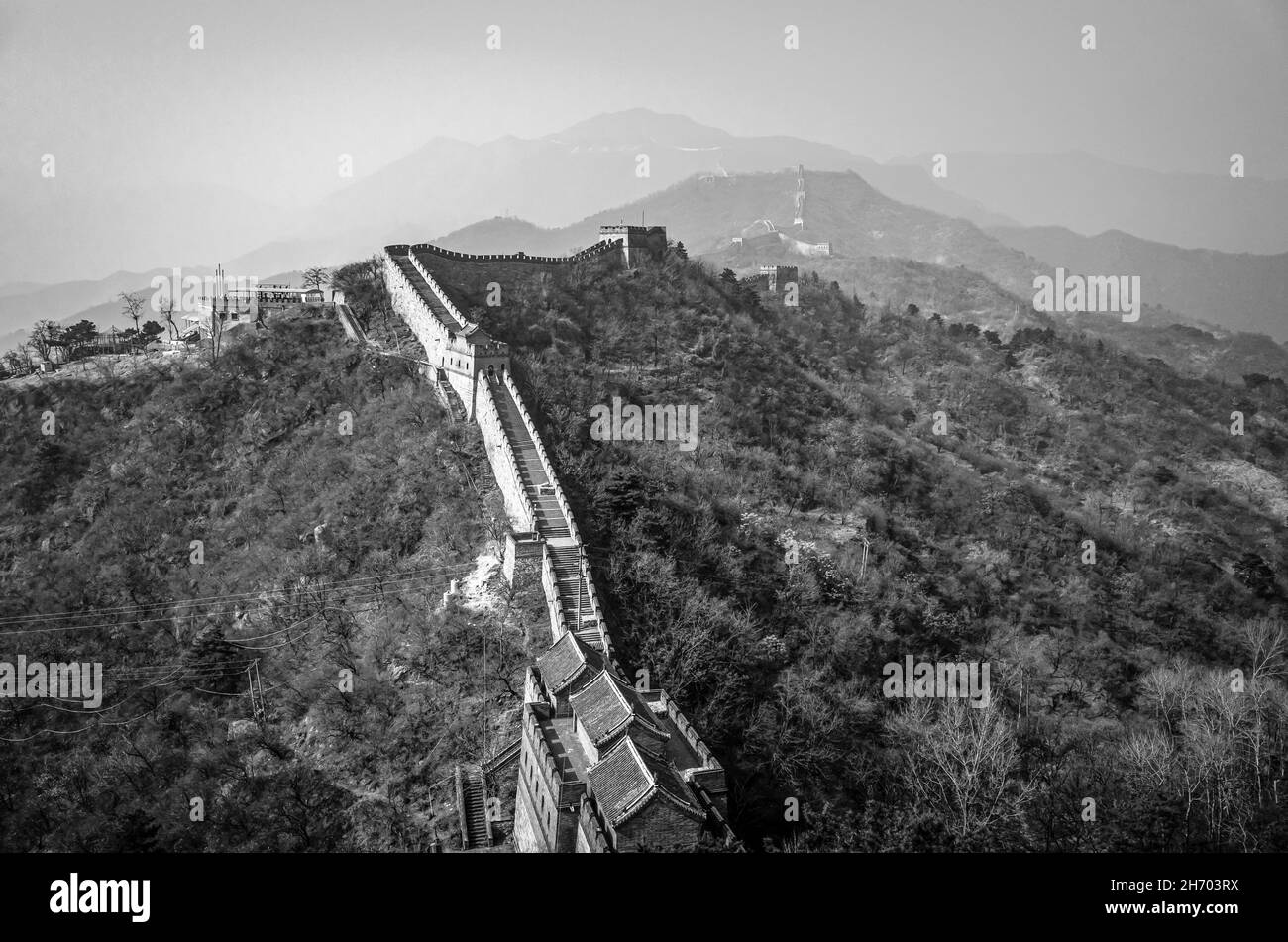Szenische Ansicht der Großen Mauer von China bedeckt mit Nebel am Morgen, Peking. Schwarz und Weiß. Stockfoto