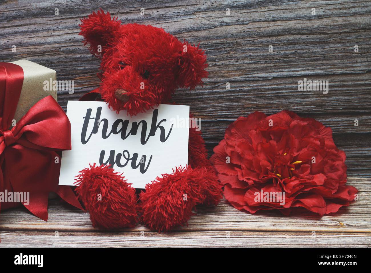 Dankeskarte mit Geschenkbox Geschenk und Blumendekoration auf Holzhintergrund Stockfoto
