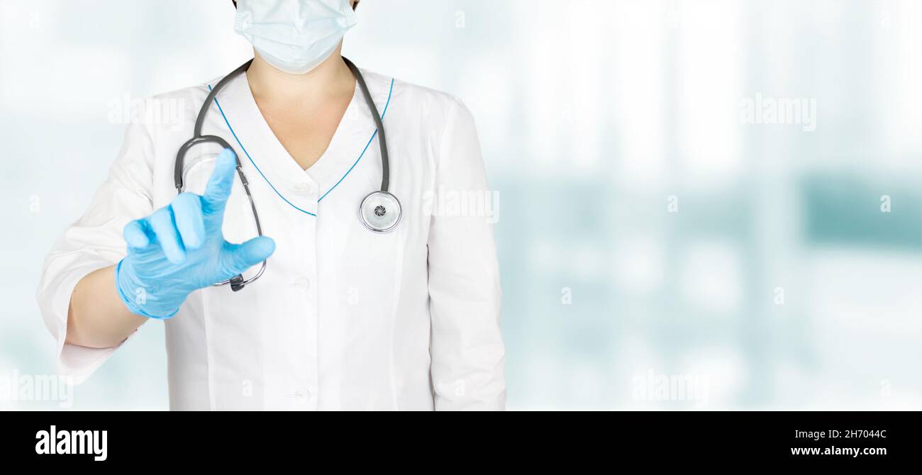 Arzthand in blauen Handschuhen drückt virtuellen Knopf im Krankenhaushintergrund, medizinisches Innovationskonzept Stockfoto