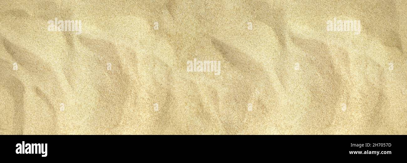 Unebene Strand Sand Foto Textur. Blick von oben auf die tropische Küste. Natürliche, glatte Sandstruktur am Strand. Trockene Sandoberfläche. Sommer Reise Hintergrund. Tropisches Meer Urlaub Banner Vorlage.Draufsicht Stockfoto