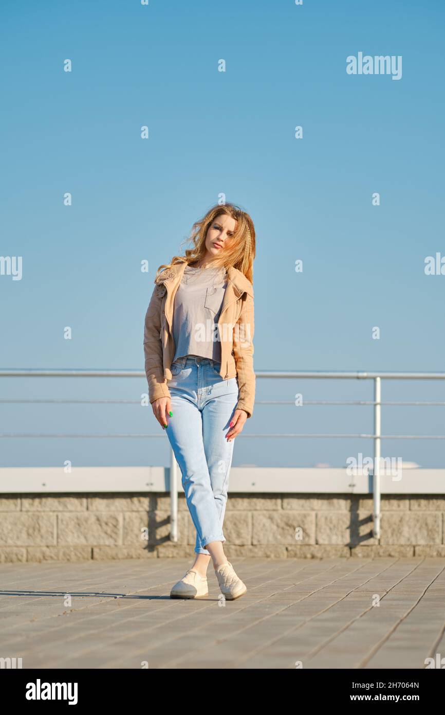 Junge Frau in legerer Kleidung, die auf der Straße posiert Stockfoto