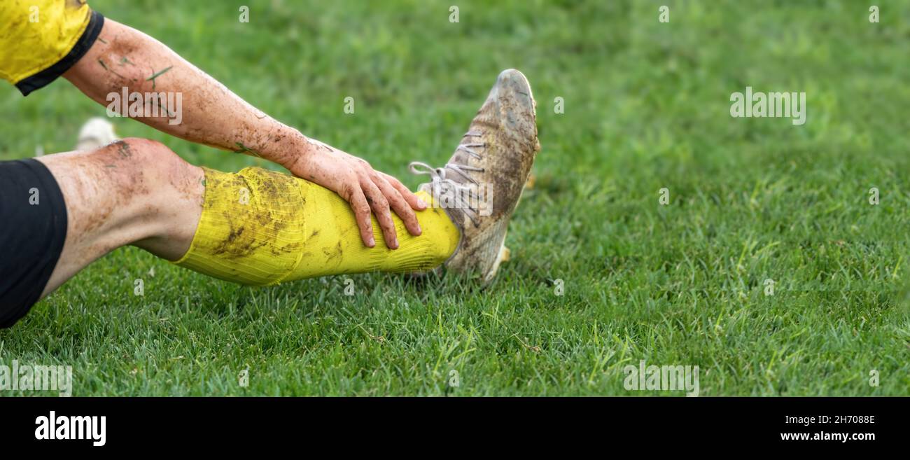 Fußball, Fußballkonzept. Der verletzte Fußballspieler legte sich auf das Feld. Verschwommener Hintergrund, Nahaufnahme. Stockfoto