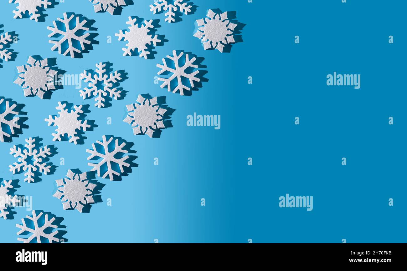 Weihnachten Hintergrund. Schneeflocken-Muster. Weiße Schneeflocken auf Blau. Schnee. Winterstimmung. Konzeptuelle Abstraktion. Styropor-Schneeflocke. Neujahrsmuster. Speicherplatz kopieren. Textur. Stockfoto