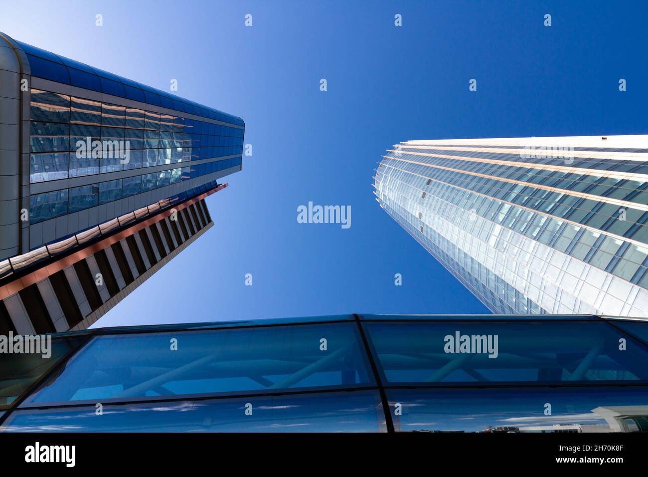 Moderner Bürohochhaus aus blauem Glas im Geschäftszentrum einer Metropole mit Reflexen vor dem blauen Himmel. Stadtlandschaft Stockfoto