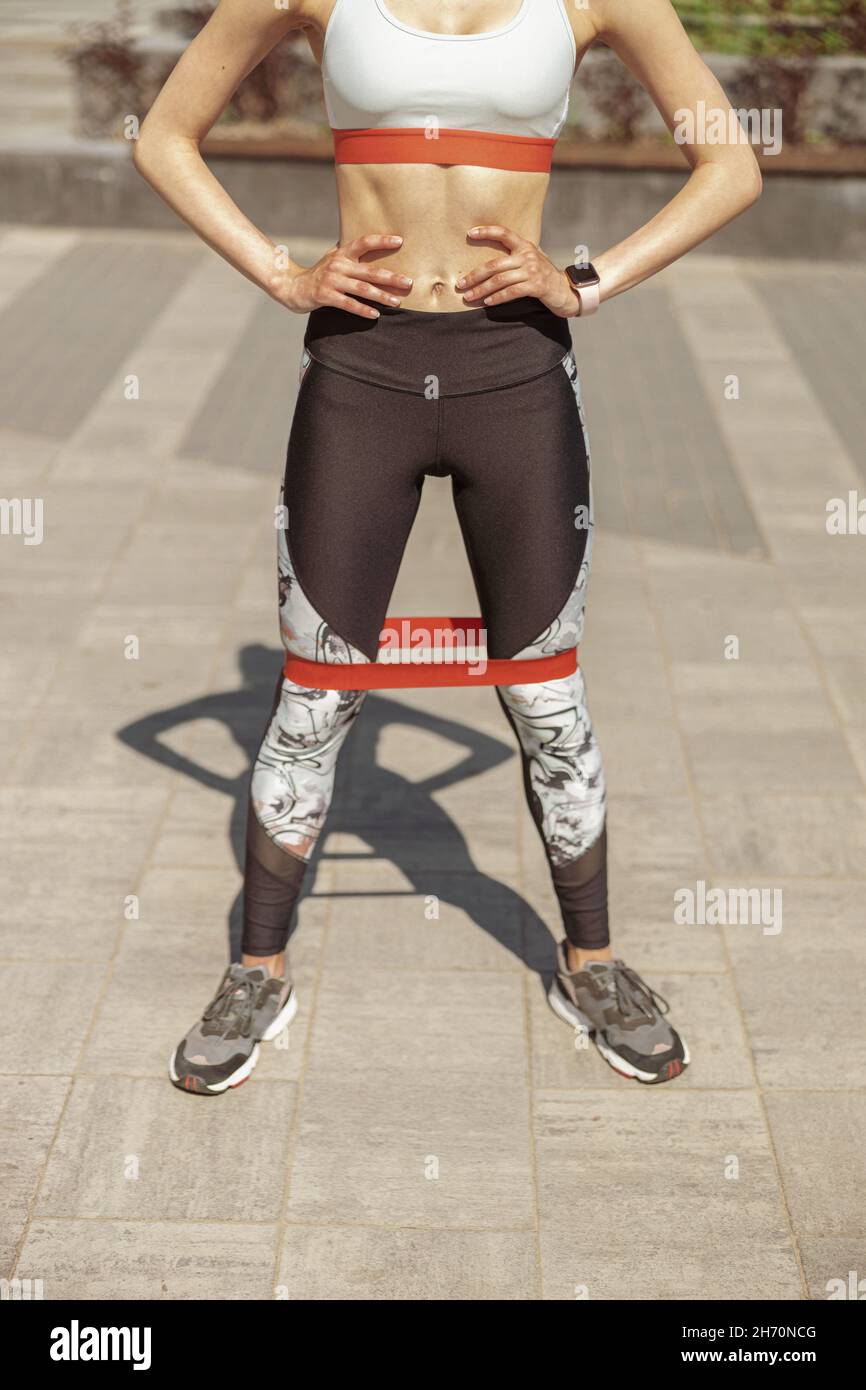 Sportliche Frau mit elastischer Biegung steht in Nahaufnahme auf der Stadtstraße Stockfoto