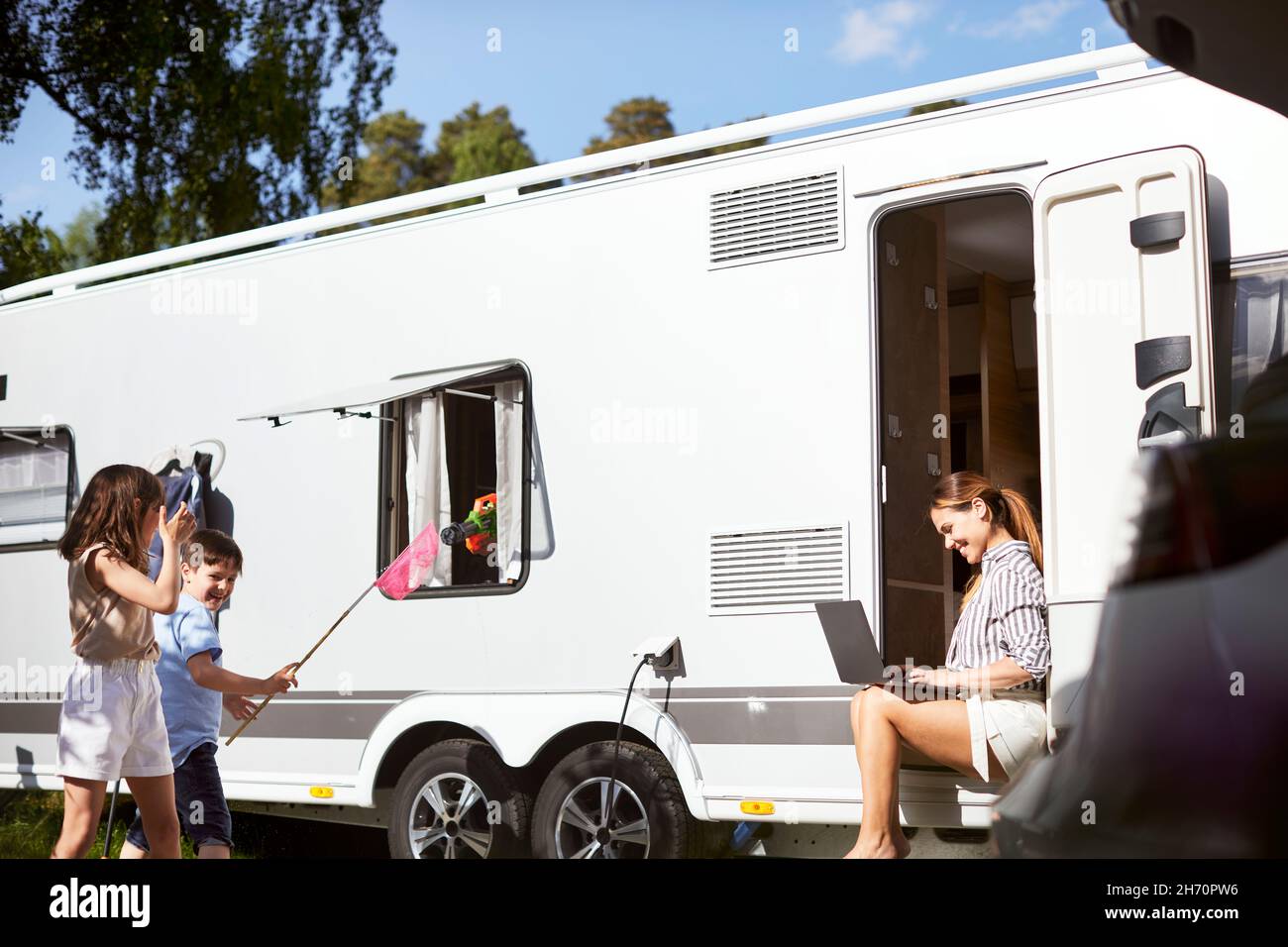Kinder spielen um Wohnwagen herum Stockfoto
