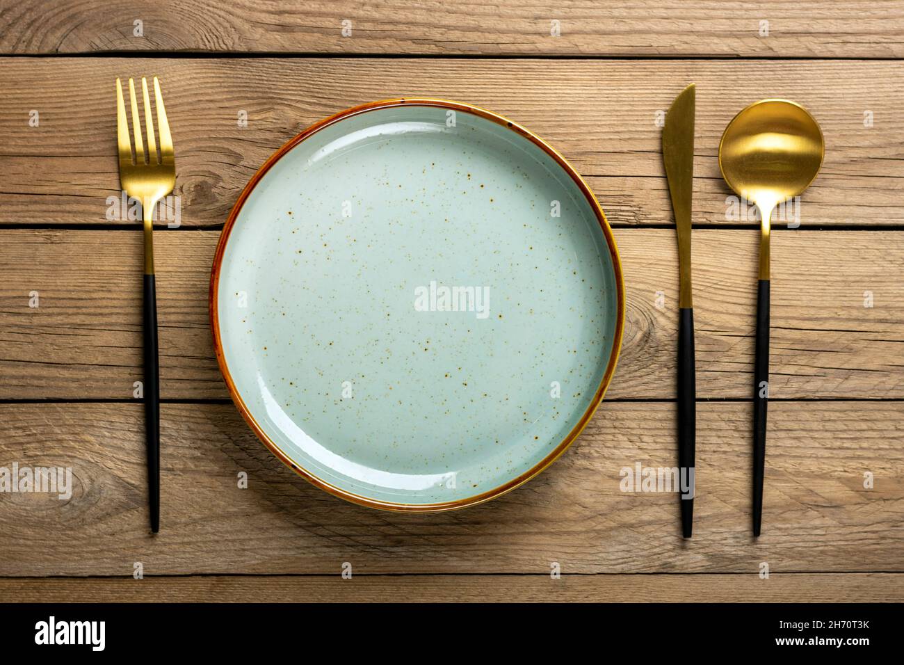 Leere runde graue Platte, Gabel, Messer, Löffel auf Holztisch Draufsicht flache Teller zum Frühstück, Mittag- oder Abendessen Mock up. Stockfoto