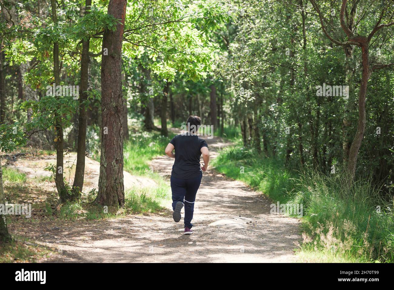 Junge Frau im Wald joggen Stockfoto