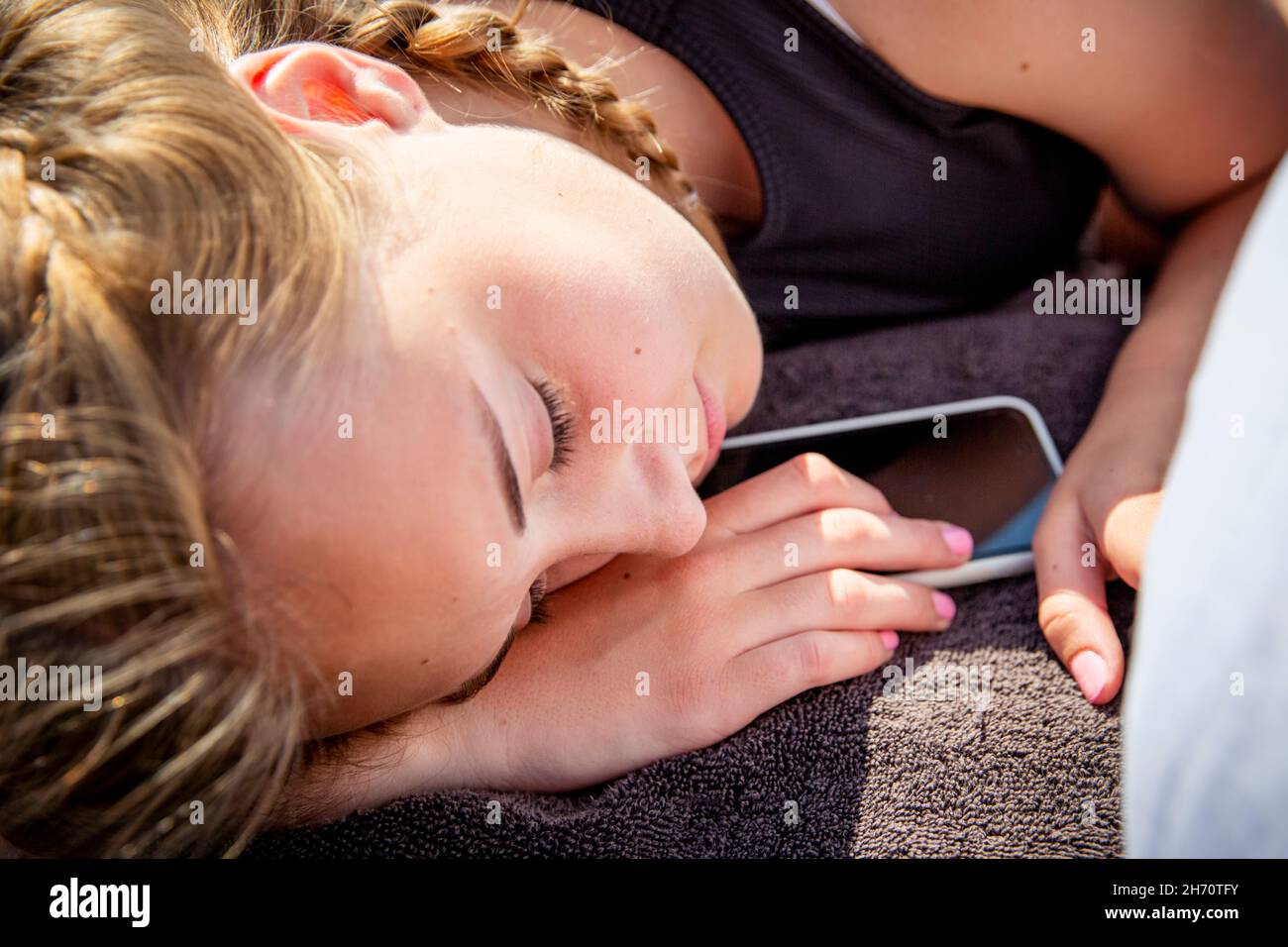 Mädchen schlafen mit Smartphone Stockfoto