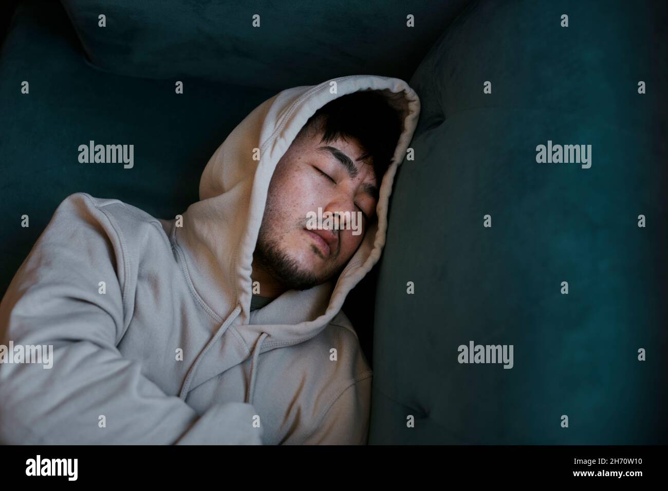Blick aus der Höhe auf den Mann, der auf dem Sofa schläft Stockfoto