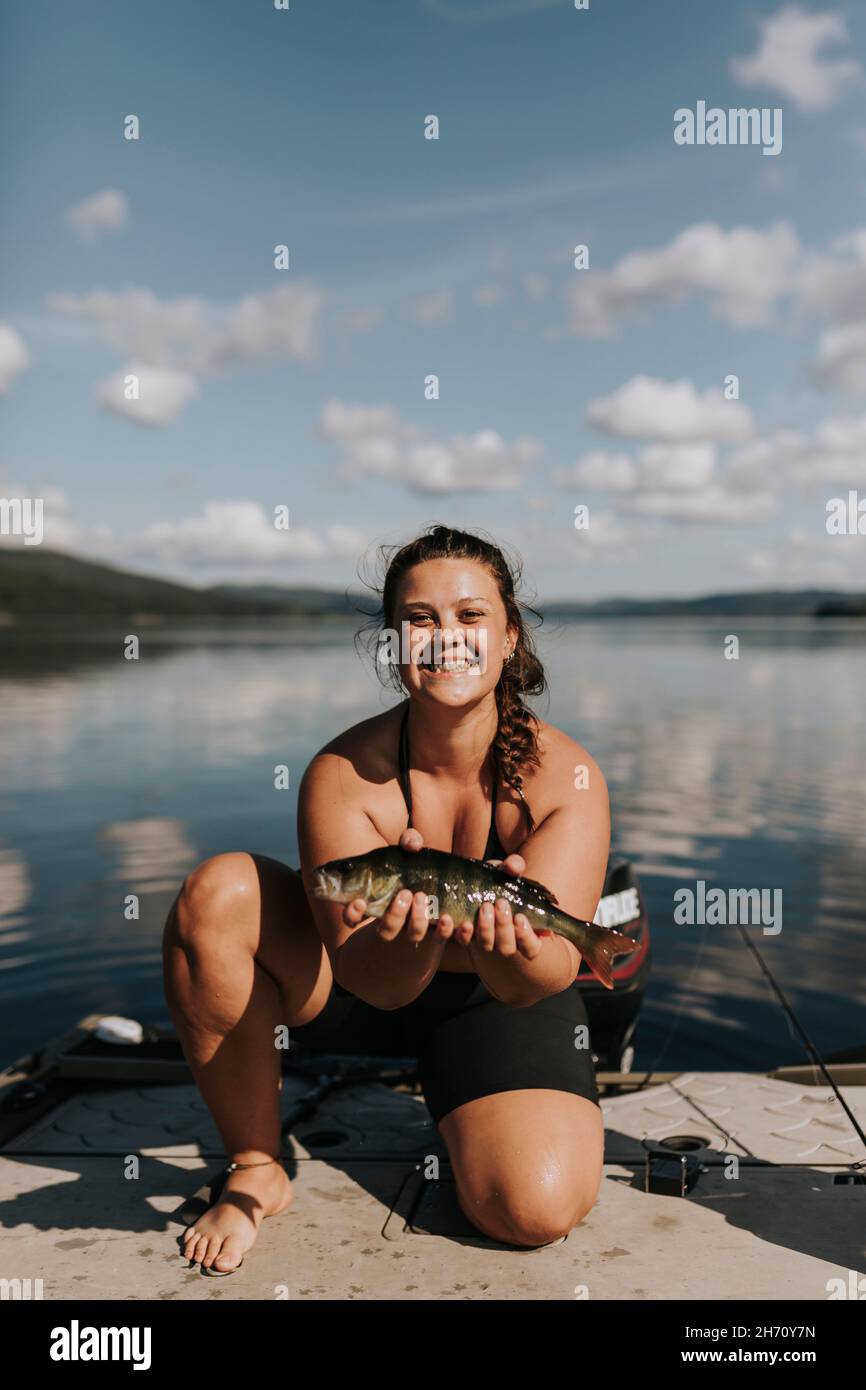 Lächelnde Frau mit Fisch Stockfoto