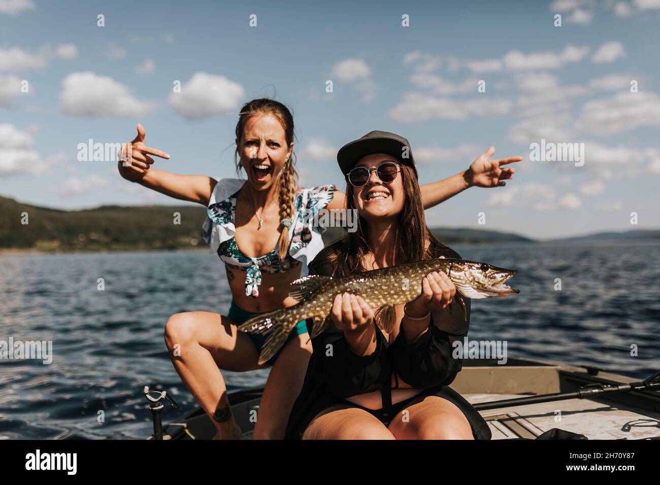 Glückliche Frauen, die Fische halten Stockfoto