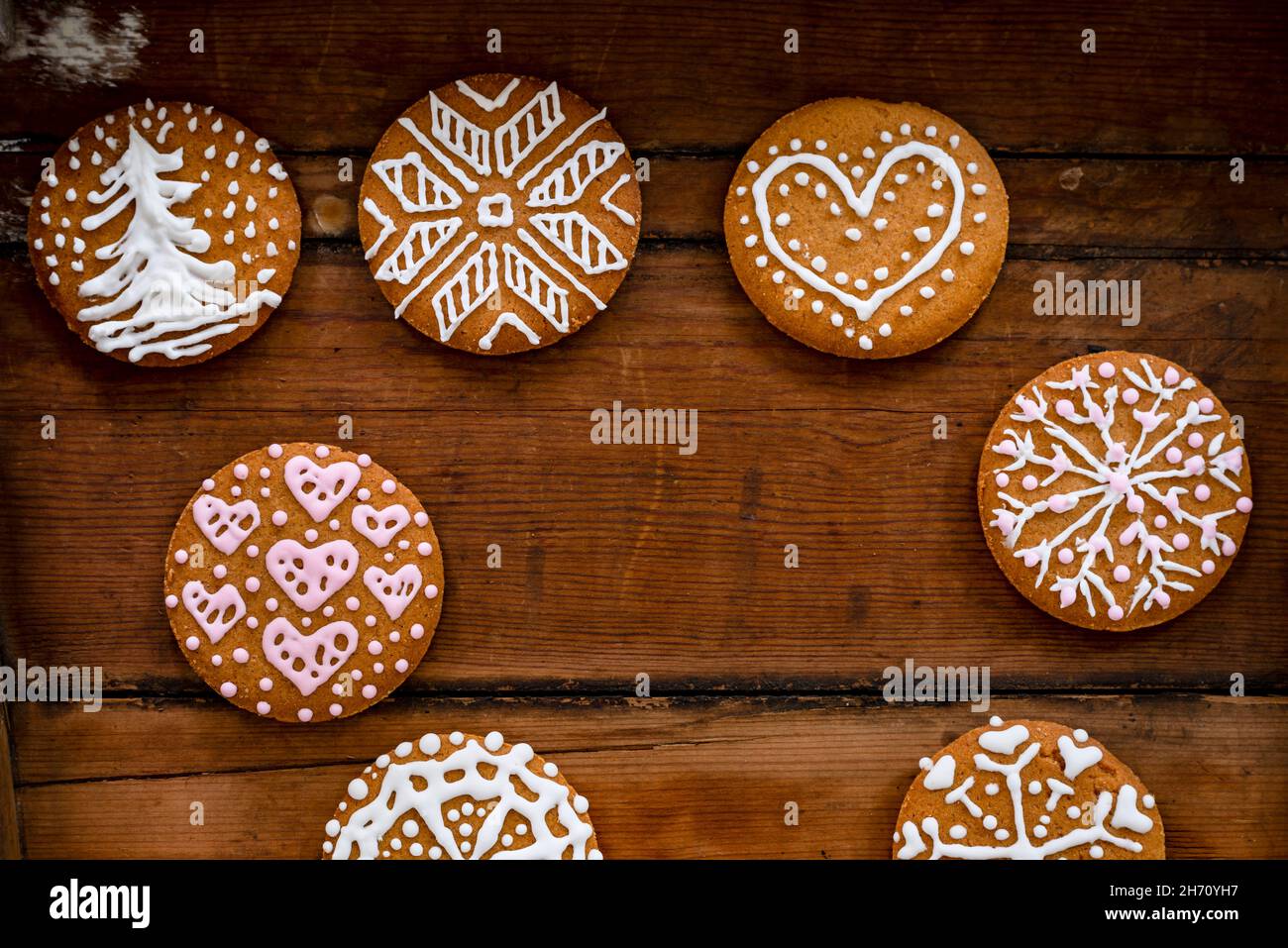 Weihnachtsplätzchen mit Glasur auf Holzhintergrund Stockfoto