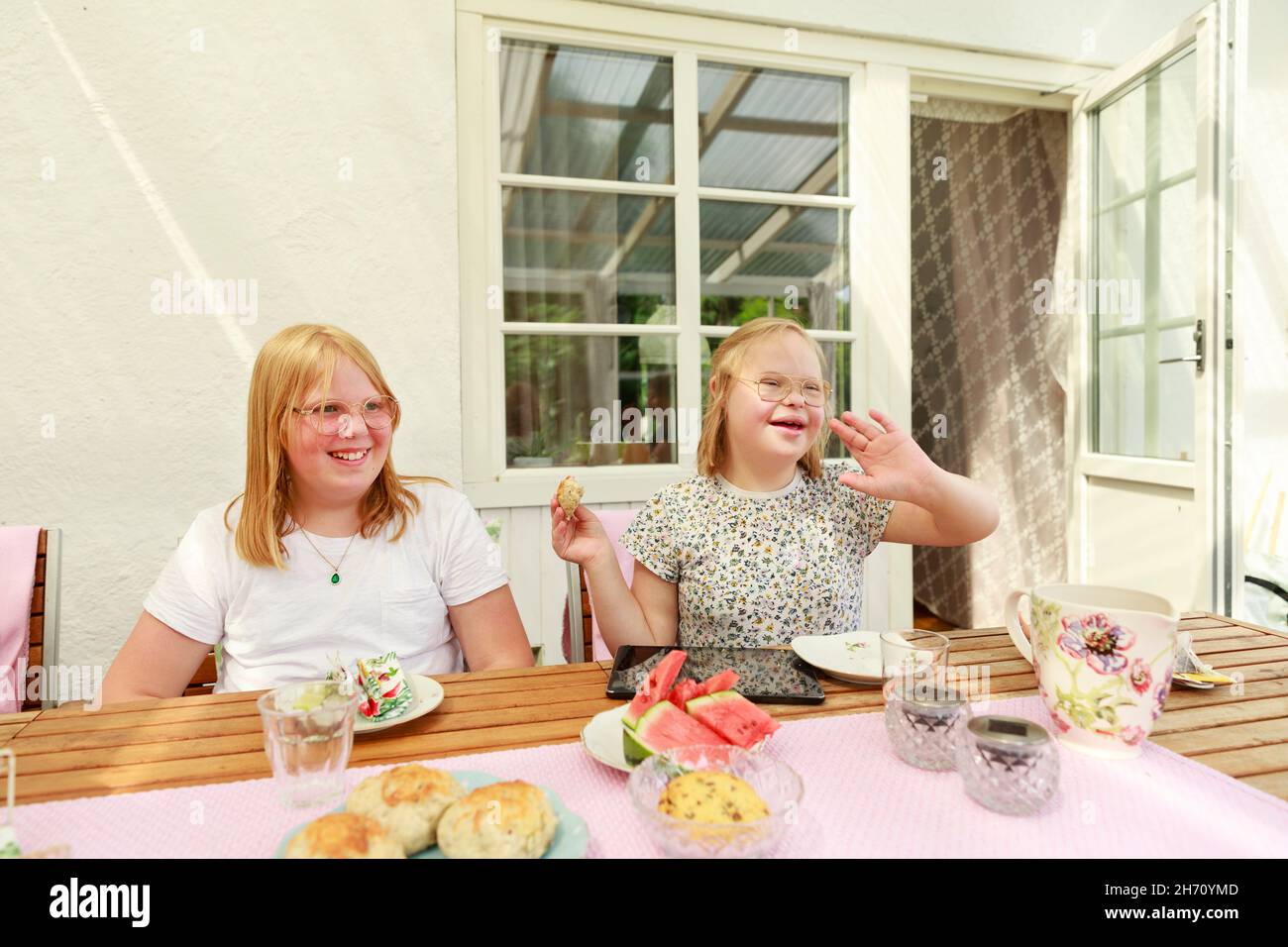 Mädchen sitzen am Tisch und essen Stockfoto
