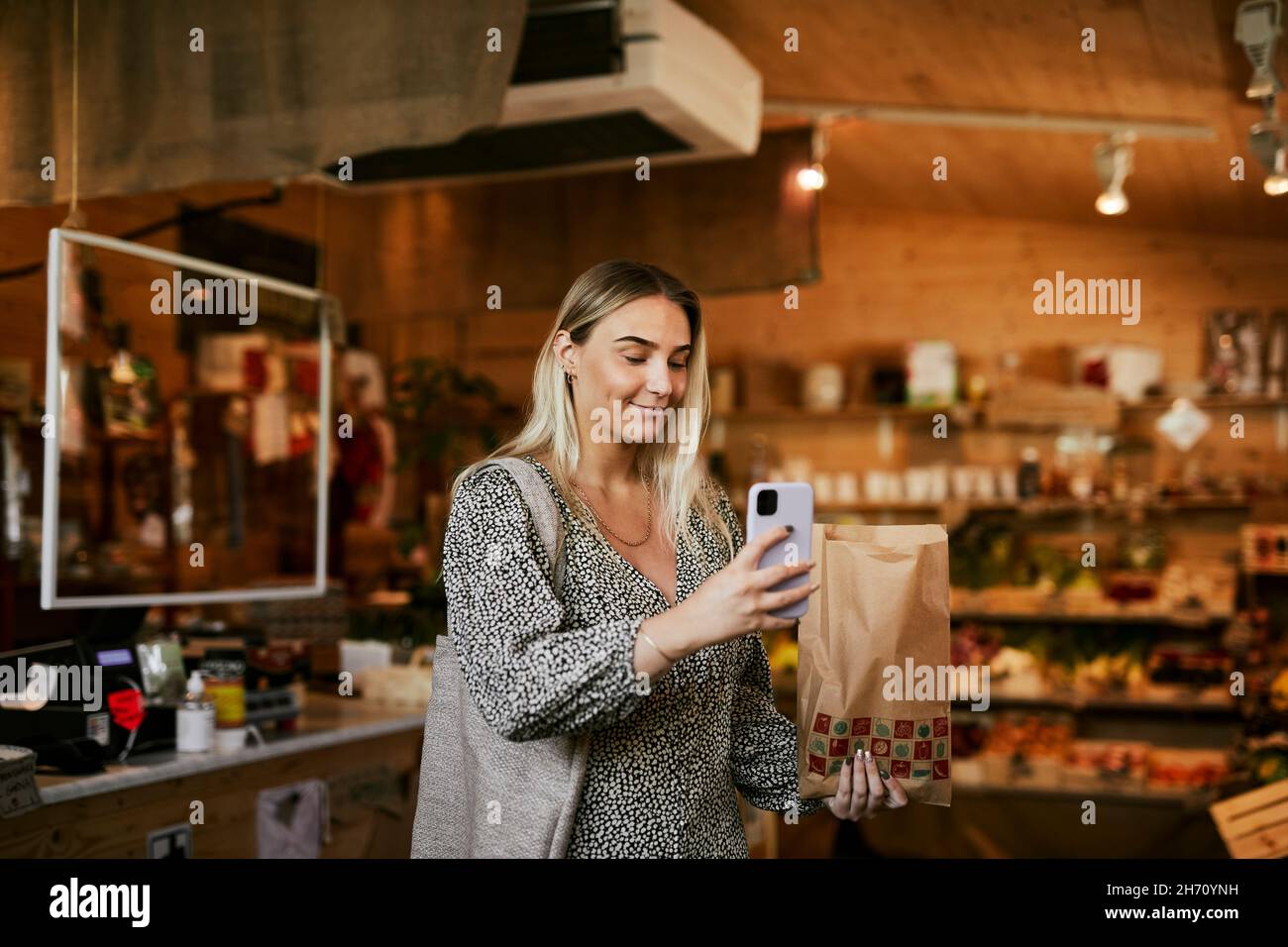 Frau, die im Geschäft mit Bio-Lebensmitteln fotografiert Stockfoto