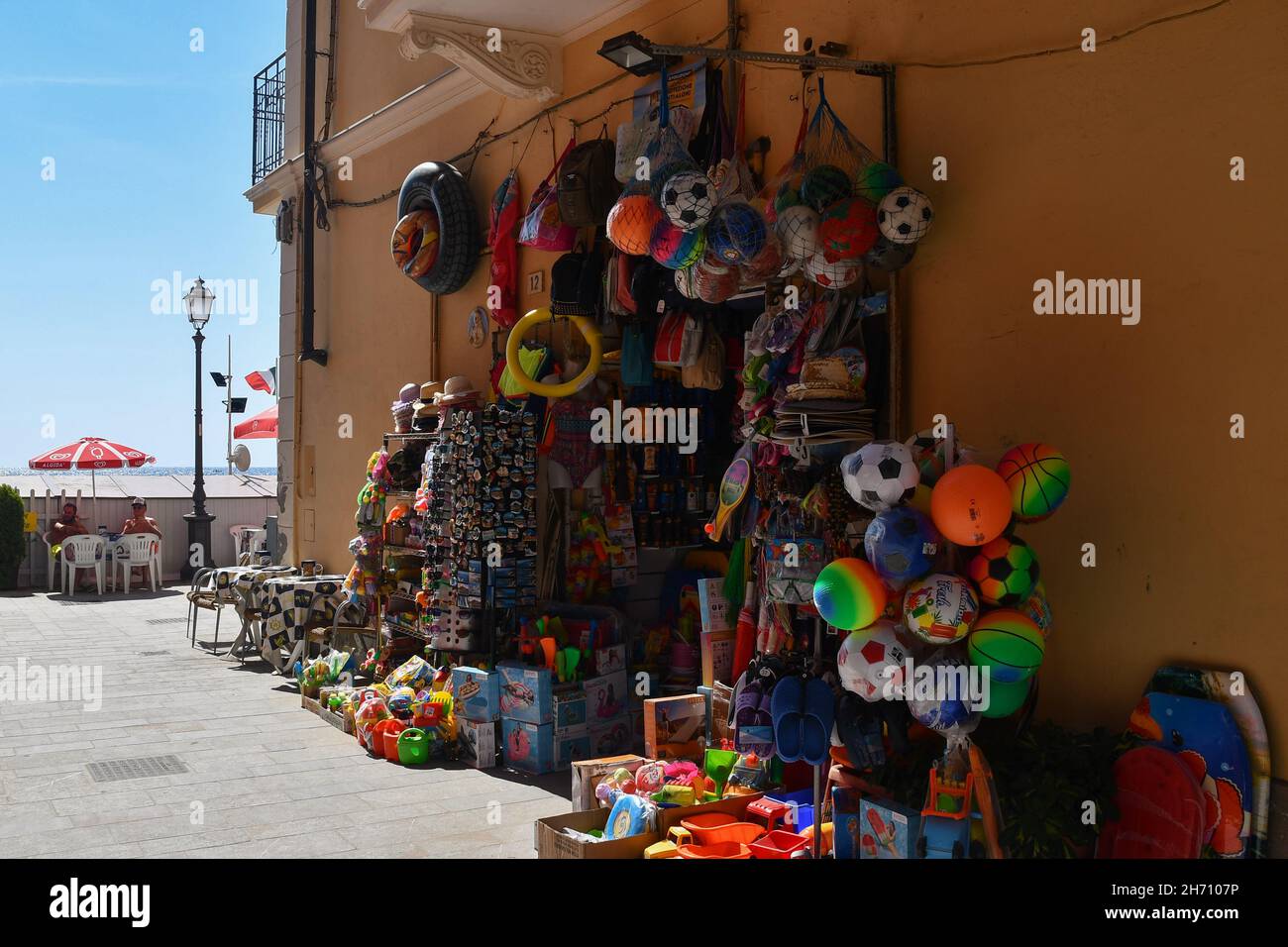Ein Touristengeschäft, das Strandspielzeug und Souvenirs an der Uferpromenade von Alassio an einem sonnigen Sommertag verkauft, Savona, Ligurien, Italien Stockfoto