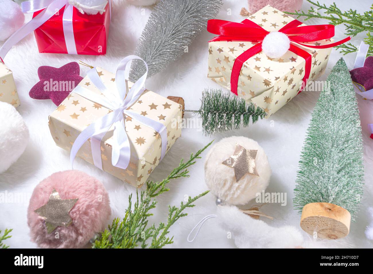 Flauschiges Weihnachtskonzept. Festliche Weihnachten Hintergrund mit Dekoration Zeug, Weihnachtskugel, Geschenk-Boxen, glänzende Sterne auf weißem flauschigen Fell Hintergrund Kopie s Stockfoto