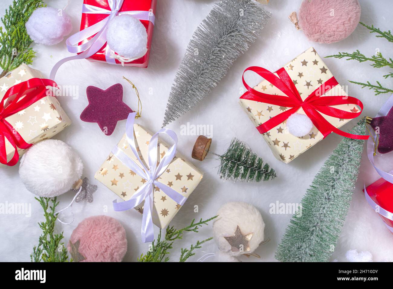 Flauschiges Weihnachtskonzept. Festliche Weihnachten Hintergrund mit Dekoration Zeug, Weihnachtskugel, Geschenk-Boxen, glänzende Sterne auf weißem flauschigen Fell Hintergrund Kopie s Stockfoto