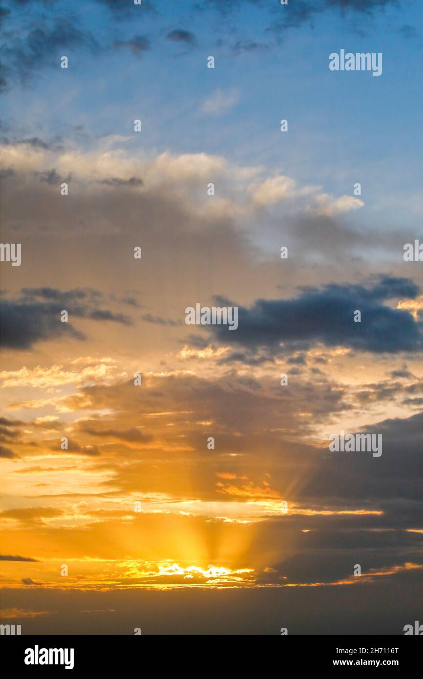 Goldene Sonnenstrahlen brechen bei Sonnenaufgang durch Wolken und bilden den Tyndall-Effekt, Schweiz. Stockfoto