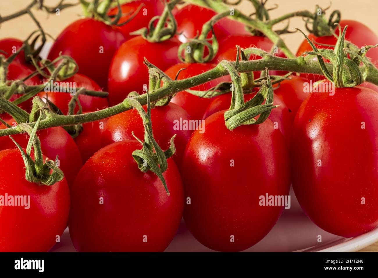 Pomodori cigliegini ein grappolo Primo Piano Stockfoto