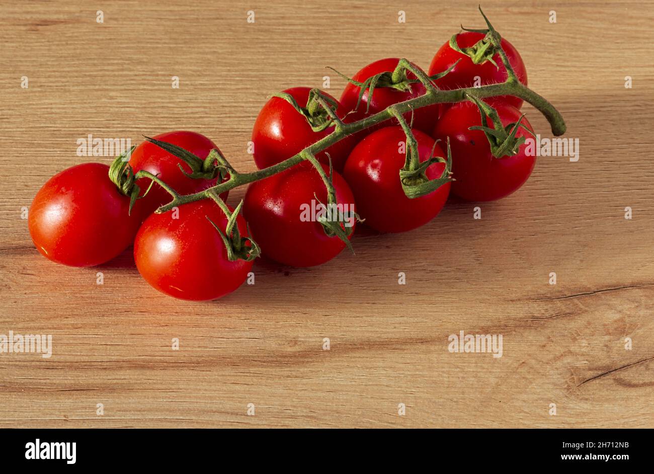 Pomodori cigliegini a grappolo sul tavolo altra vista Stockfoto