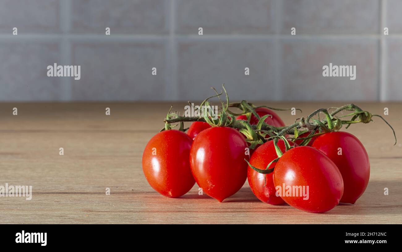 Pomodori cigliegini a grappolo sul tavolo spazio copia Stockfoto