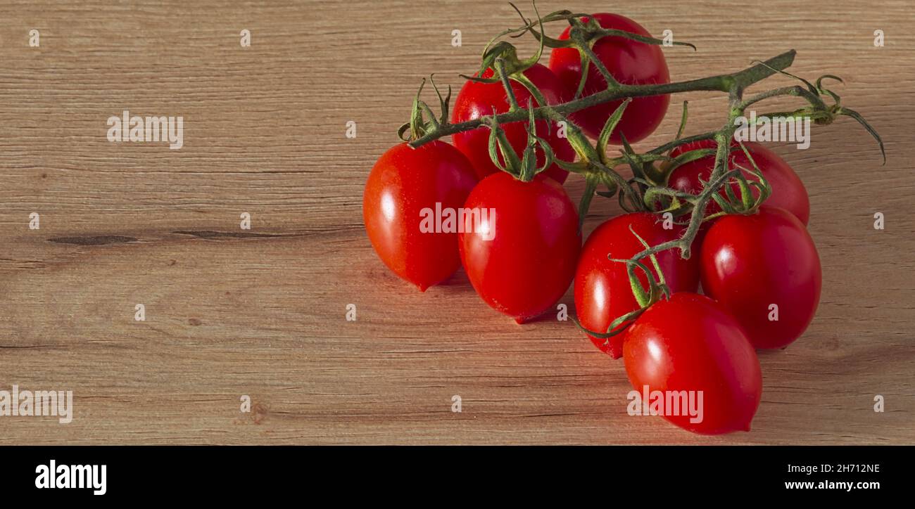 Pomodori cigliegini a grappolo sul tavolo vista da sopra spazio copia Stockfoto