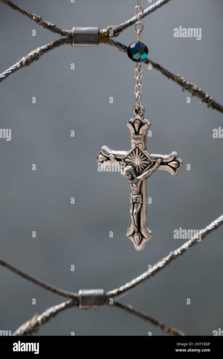 Metallkreuz mit dem gekreuzigten Jesus auf grauem Hintergrund Stockfoto