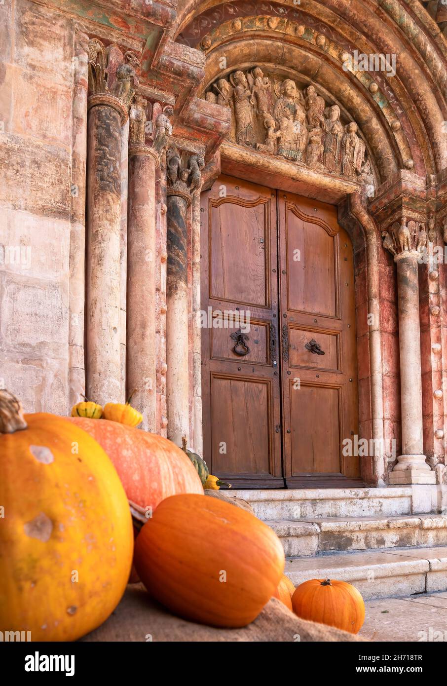 Die Tür der Stiftskirche in Saint Ursanne und dekorative Kürbisse an Thanksgiving Stockfoto