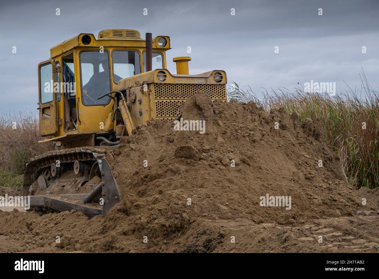 Bul'dozer entfernt den Damm im Donaudelta. Nahaufnahme Stockfoto