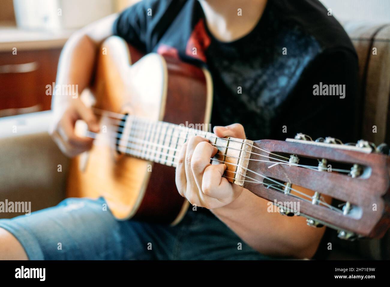 Gitarrenunterricht für Anfänger. Nahaufnahme der Hände, die Gitarre spielen. Online-Gitarrenunterricht, genießen Lieblings-Hobby, Freizeit. Akustische Gitarren für Stockfoto