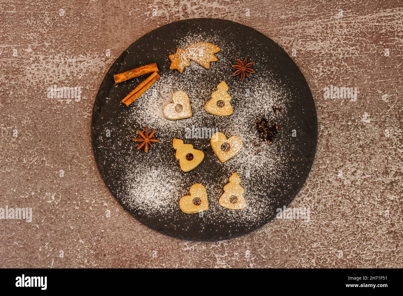 Leckere hausgemachte Kekse auf dunklen Teller.Weihnachts-Cookie-Muster.Winterferien Dessert Ornament Raum für Text.Weihnachten Gewürze.traditionelle Linzer Weihnachten Stockfoto