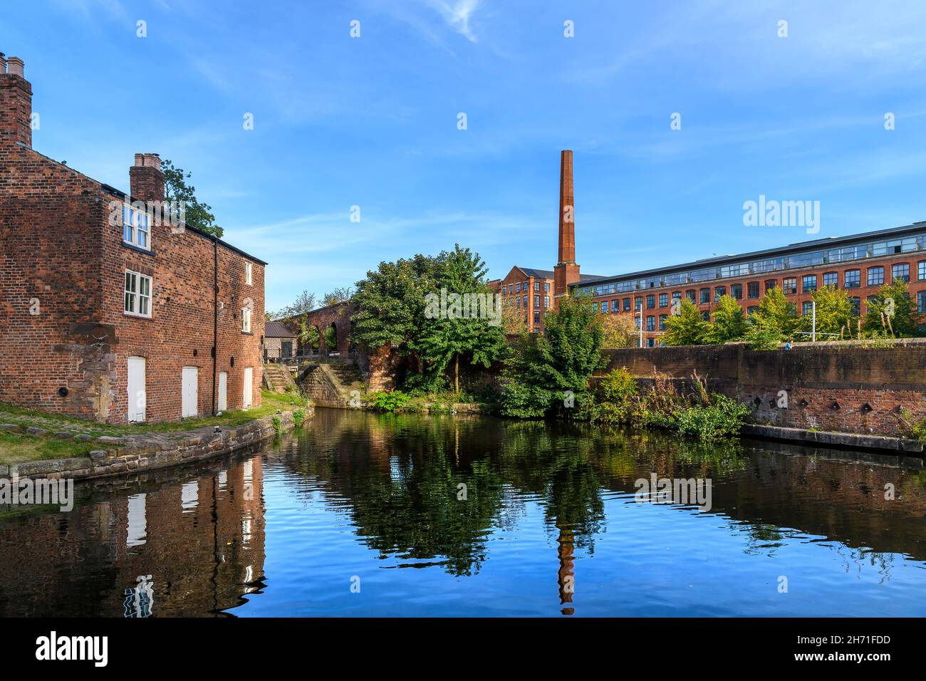 Hütte des Schleusenwärters am Ashton-Kanal im Stadtteil Ancoats von Manchester. Das Albion Works-Fabrik-Apartmentgebäude befindet sich im Hintergrund. Stockfoto