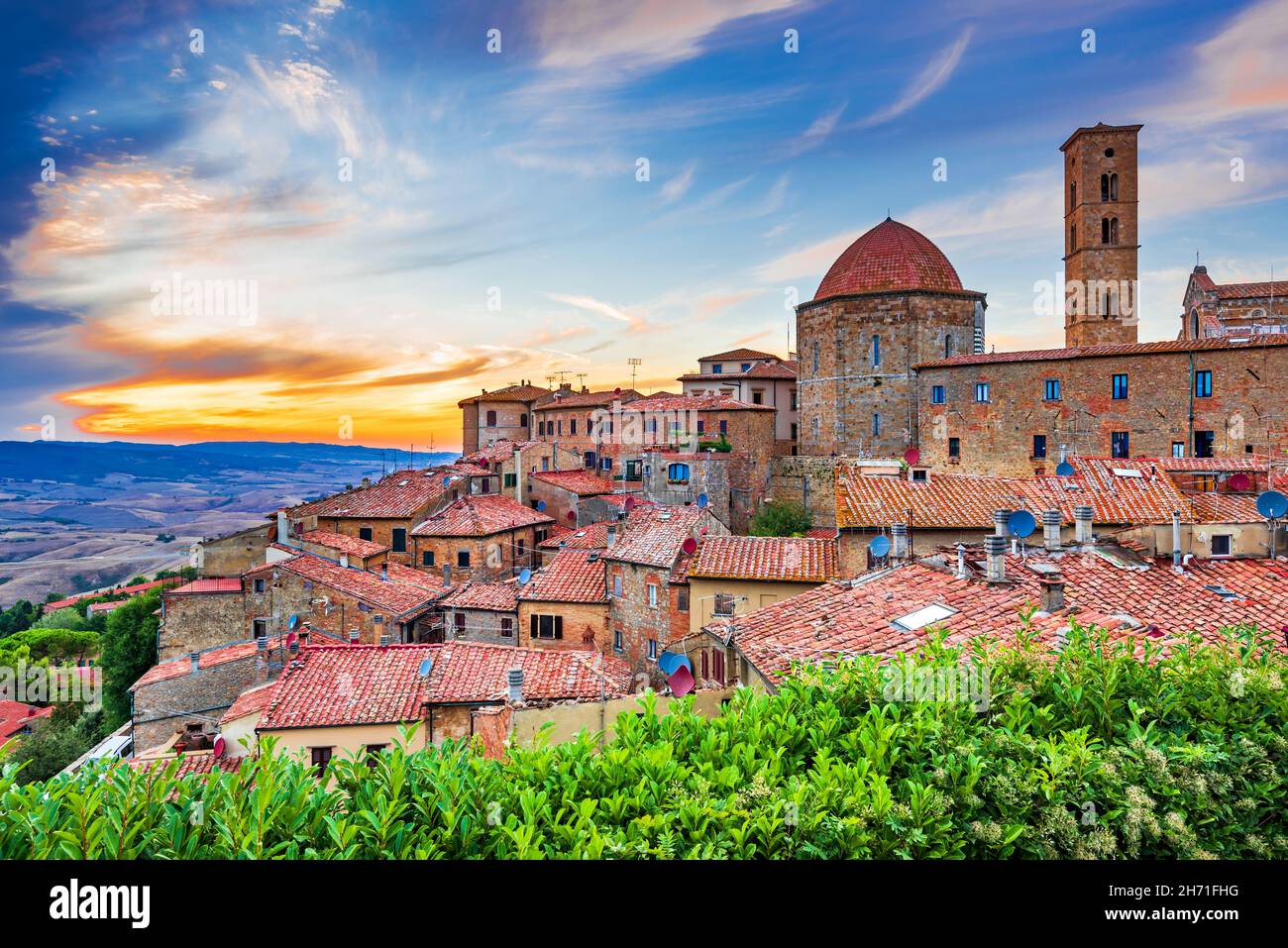 Volterra, Toskana. Panoramablick Sonnenuntergang Volterra - mittelalterliche toskanische Stadt mit alten Häusern, Türmen und Kirchen in Italien. Stockfoto