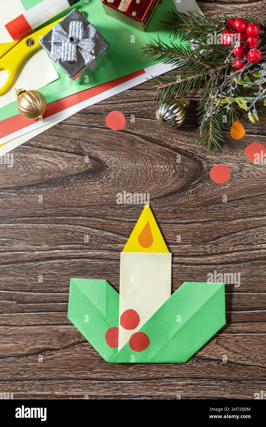 Weihnachten Grußkarte Geschenk Origami Kerze auf Holztisch. Kinderkunstprojekt, handgefertigt, Basteln für Kinder. Stockfoto