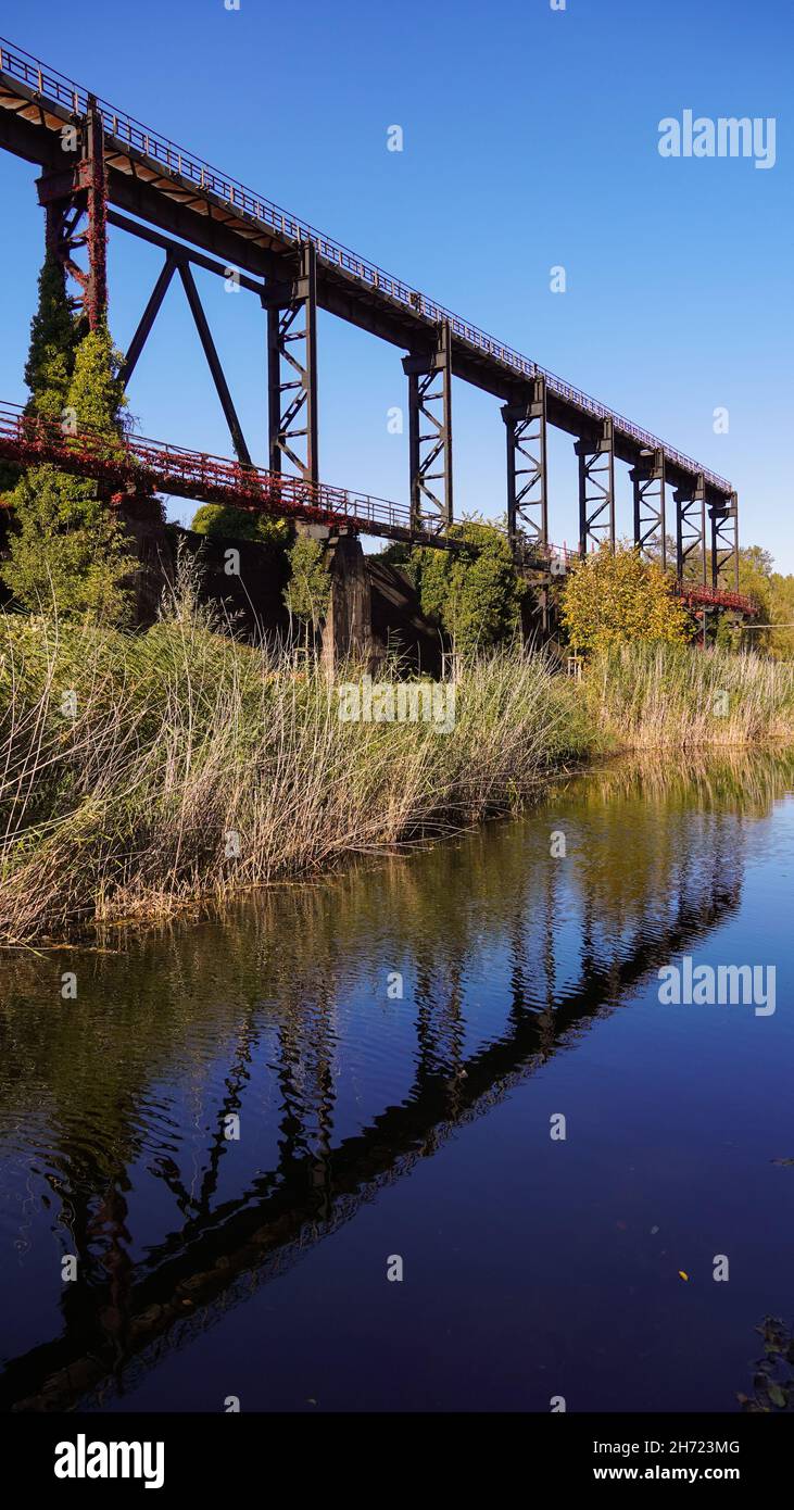 Alte rostige Industriebrücken im Gegensatz zur Natur Stockfoto