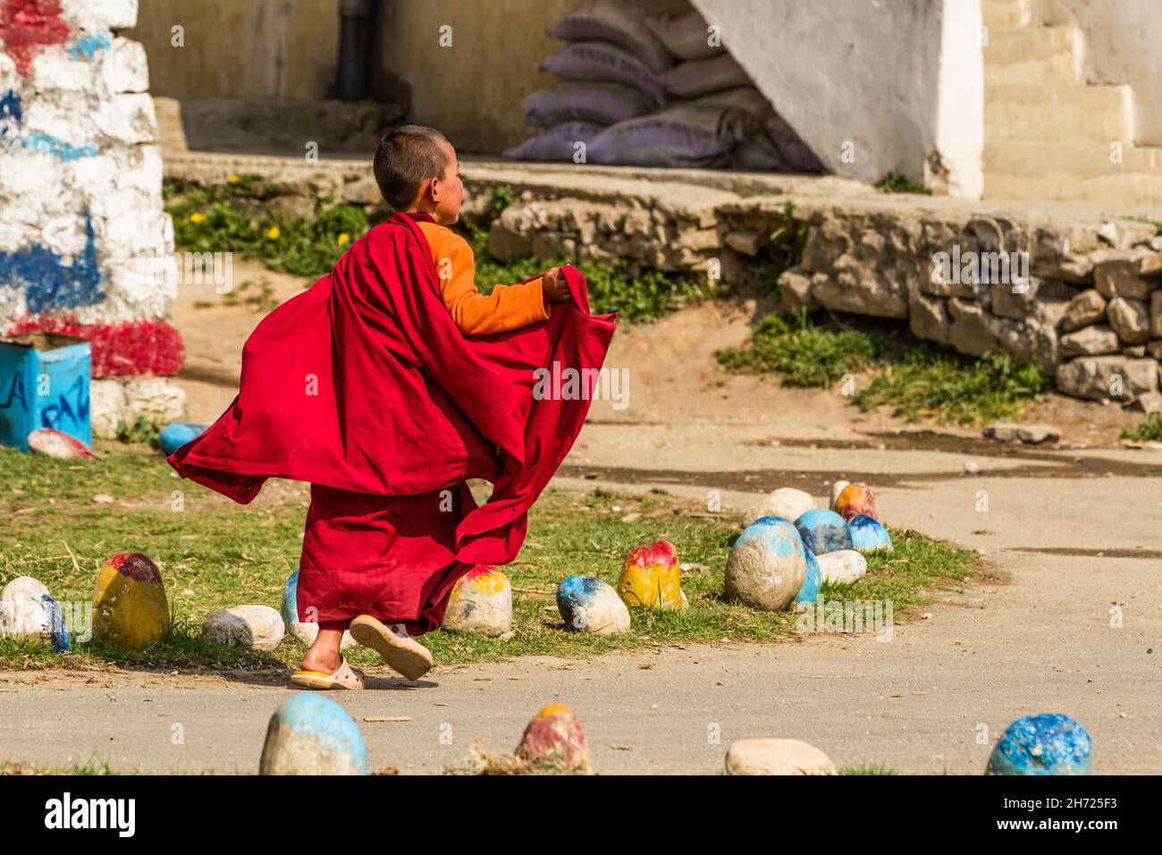 Ein junger buddhistischer Novizenmönch läuft an der Dechen Phodrang Klosterschule in Thimphu, Bhutan, um sich in eine Schlange zu stellen. Stockfoto