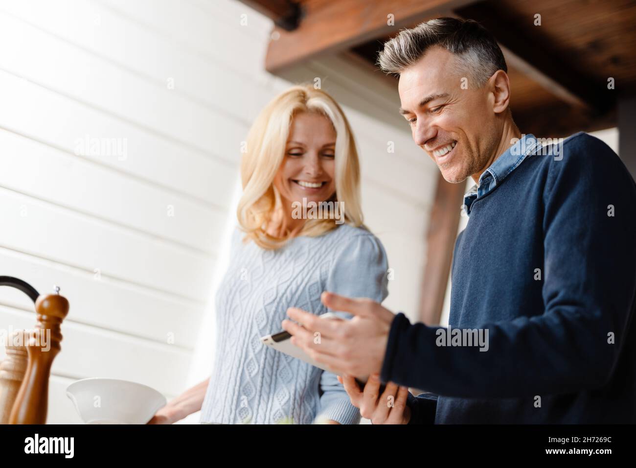 Happy Mid Whute Pärchen websurfing mit Tablet in der heimischen Küche und frühstückte Stockfoto