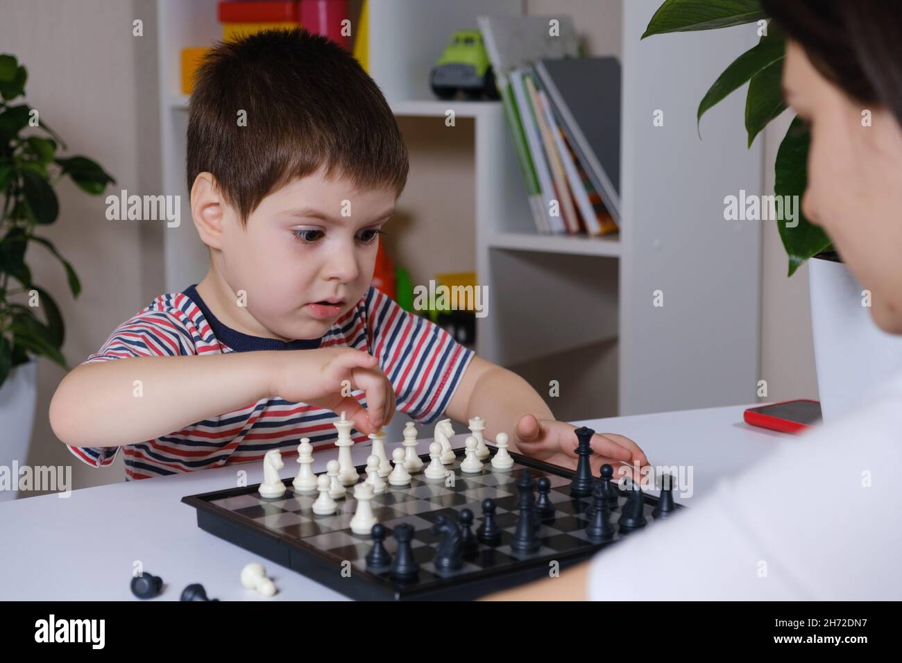 Mutter und Sohn von 4 Jahren Schachspiel. Entwicklung für Vorschulkinder, Lernen Brettspiele Stockfoto