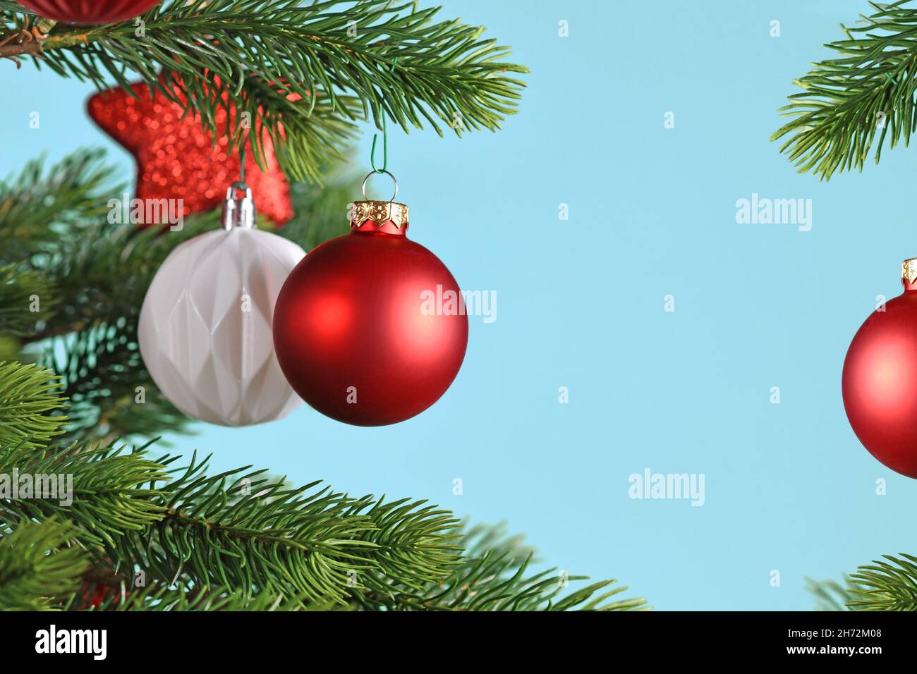 Rote Weihnachtskugeln auf Weihnachtsbaum auf blauem Hintergrund mit Kopierplatz Stockfoto