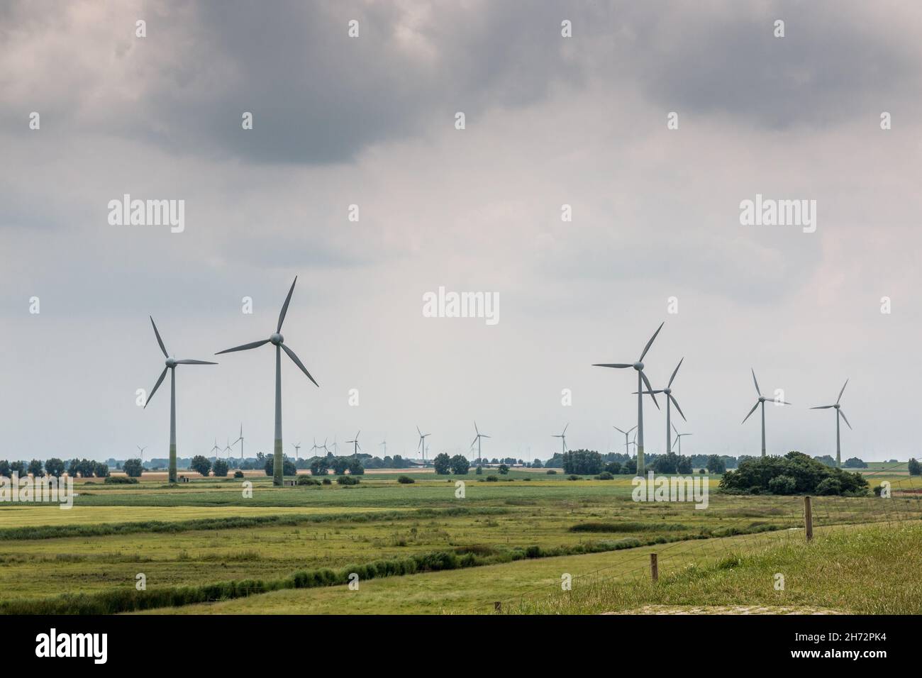 Windräder für erneuerbare Energie auf dem flachen Marschland Norddeutschlands Stockfoto