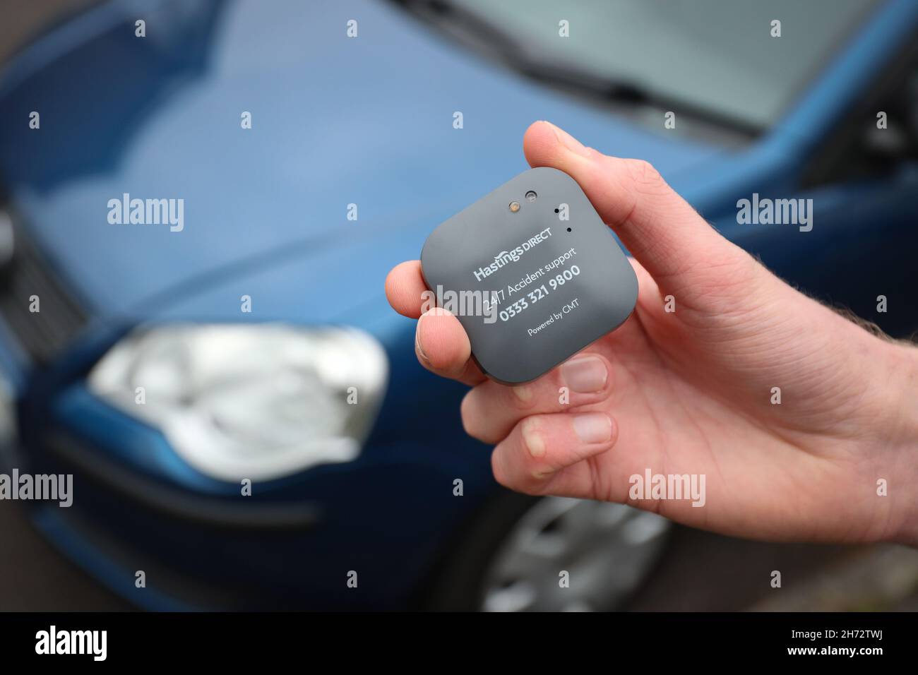 Ein junger Fahrer, der kurz vor der Installation einer britischen Telematik-Blackbox für Kfz-Versicherungen in sein neues Auto steht. Stockfoto