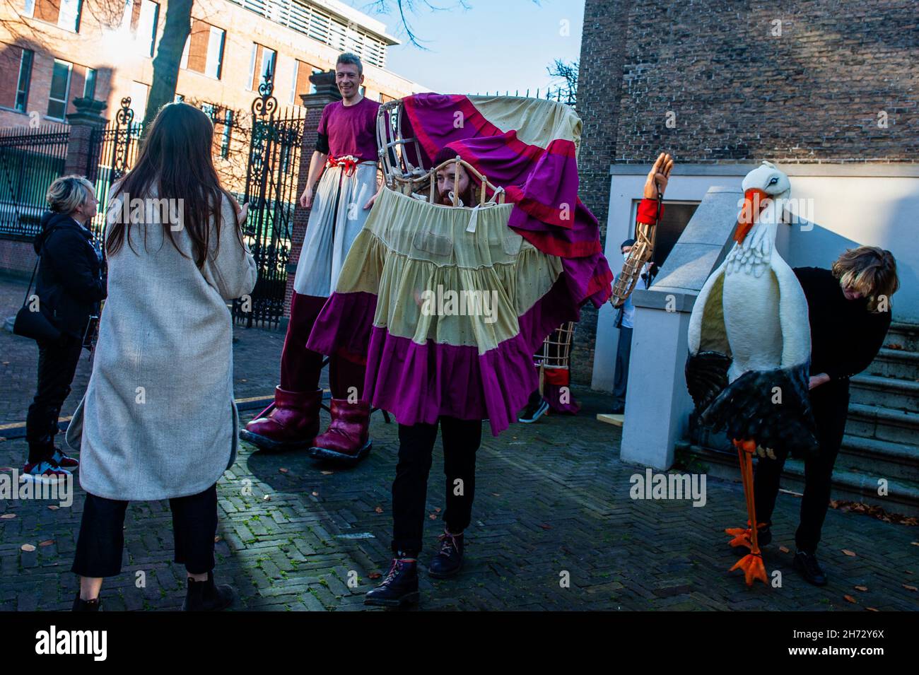 Den Haag, Niederlande. 19th. November 2021. Am letzten Tag ihres Besuchs in den Niederlanden spazierte die riesige Marionette „Little Amal“, ein neun Jahre altes syrisches Flüchtlingsmädchen und über 11 Meter groß, durch das Stadtzentrum von Den Haag, wo sich das Repräsentantenhaus befindet, Mit den Menschen auf der Straße zu interagieren. Dieser Besuch wurde von Amare organisiert, einem neuen kulturellen Zentrum im Rahmen des Open Festivals. Mit ihrem Besuch will Amal in ganz Europa die Aufmerksamkeit auf die Not junger Flüchtlinge lenken, die aus Syrien geflohen sind. Während ihres Besuchs im c Stockfoto