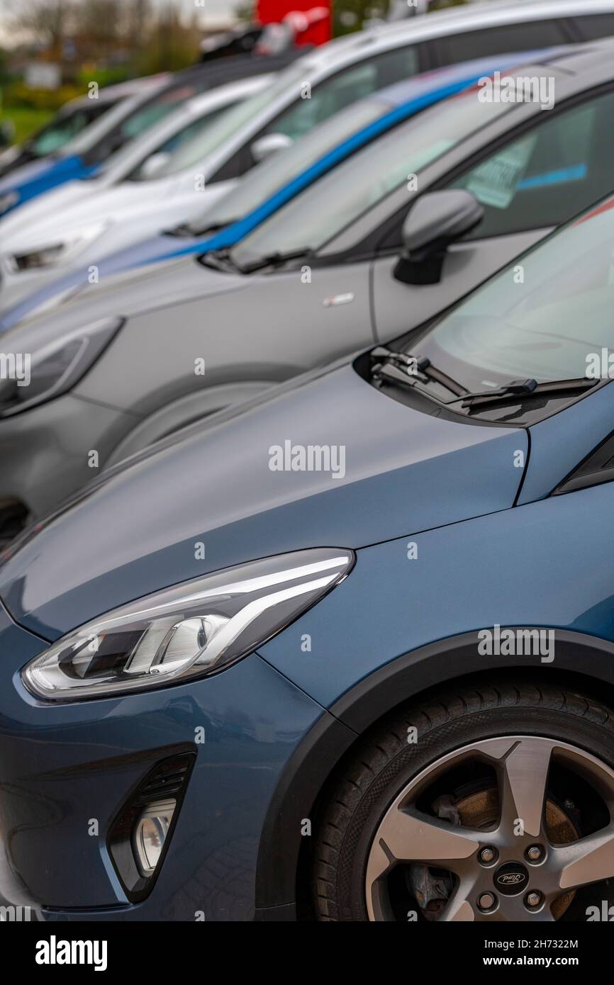 Reihe oder Reihe von Neuwagen zum Verkauf auf dem Vorplatz eines Garagenhändlers, Neuwagen auf dem Display eines Autohauses, Garagenvorplatz mit Neuwagen. Stockfoto